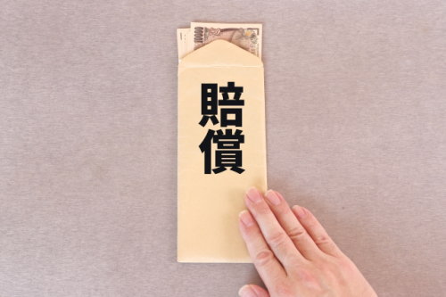 賠償と書かれた封筒の中にある一万円札の束